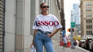 Person styling an oversized t-shirt with jeans and accessories